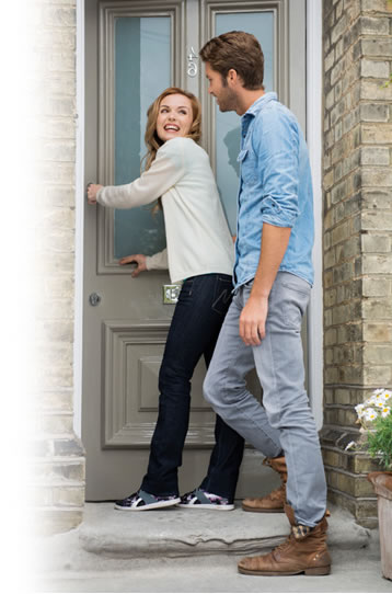 happy couple opening their front door